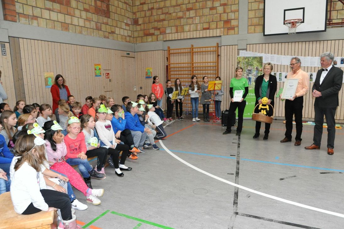 Schulleiter Armin Loos (2.v.r.) zeigt den Züscher Grundschülern die Urkunde, die für den Naturpark Saar-Hunsrück Vorsitzender Matthias Schneider (rechts) überreichte, während Geschäftsführerin Gudrun Rau (3.v.r.) Geschenke mit brachte. Foto: Schmieder