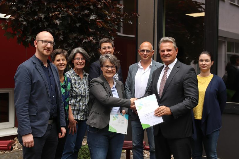 Schulleiterin Birgit Barrelmeyer (m.) nahm von Landrat Günter Rosenke (2.v.r.) das Siegel und die Urkunde in Empfang.  Foto: Tim Nolden