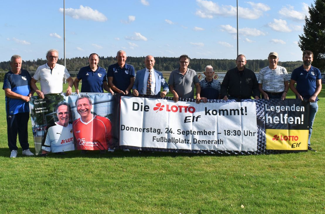 Verantwortliche von FC Demerath, Lotto-Elf und Club Fifty-One präsentieren das Banner zum Benefizspiel am 24. September.