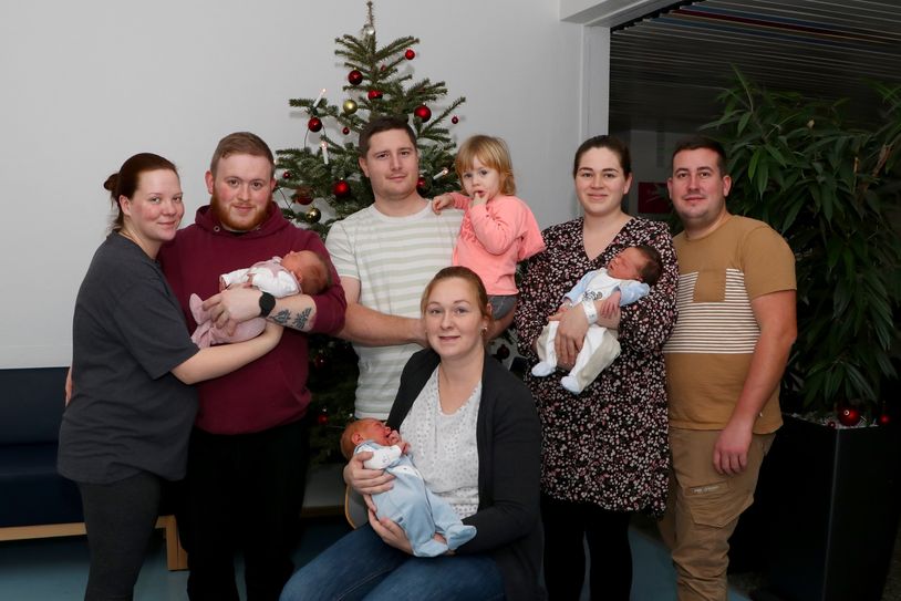Halten ihre Weihnachtsgeschenke in den Armen: Michelle und Tarik Backes mit Grace, Madlen und Jan-Michael Müller mit Matheo sowie Liane und Christian Kanzler mit Silas Matteo.