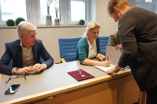 Claudia Niessen, Eupener Bürgermeisterin und zugleich Präsidentin der Hilfeleistungszone der DG, unterzeichnet die Vereinbarung, links daneben der Bürgermeister der Gemeinde Büllingen, Friedhelm Wirtz