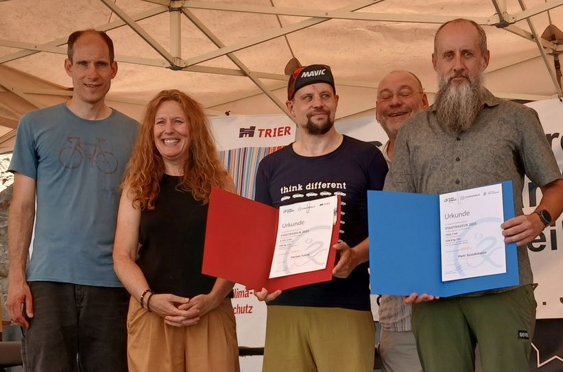 Florian Teklik (Mitte/Stadt Trier) und Piotr Szuszkiewicz (r., Kreis Trier-Saarburg) werden von den Beigeordneten Thilo Becker (l.) und Iris Molter Abel (2.v.l.) sowie Klimaschutzmanager Hendrik Wisbar (2.v.r.) als beste Einzelteilnehmer beim Stadtradeln geehrt.
