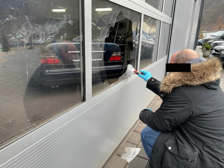 Spurensuche am Tatort in Ernst: Ein Kripobeamter sucht nach Fingerabdrücken am Werkstatttor, durch das die Täter ins Autohaus „HZ-Automobile“ eingedrungen waren. Foto: Zender