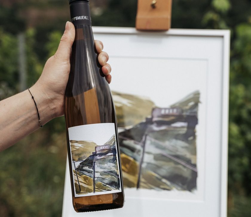 Welterbe-Wein 2024  des Siegerweinguts Philipps-Mühle (St. Goar) mit einem Etikett von Clara Schuster und Anne Nilges.