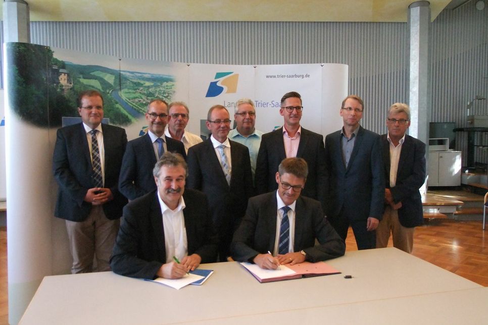 Landrat Günther Schartz (vorne rechts) und Lothar Oelert, RWE Rheinland Westfalen Netz AG, haben den Ausbauvertrag für das Breitbandnetz im Beisein von Vertretern der VGs unterschrieben. Foto: Freund
