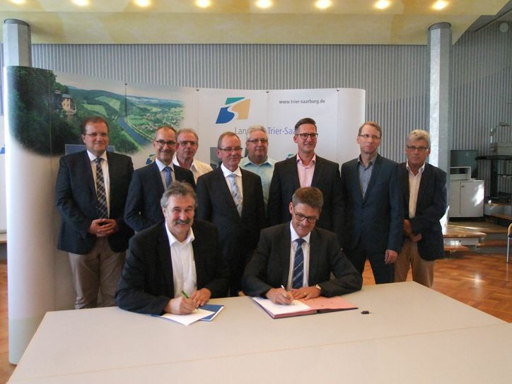 Landrat Günther Schartz (vorne rechts) und Lothar Oelert, RWE Rheinland Westfalen Netz AG, haben den Ausbauvertrag für das Breitbandnetz im Beisein von Vertretern der VGs unterschrieben. Foto: Freund