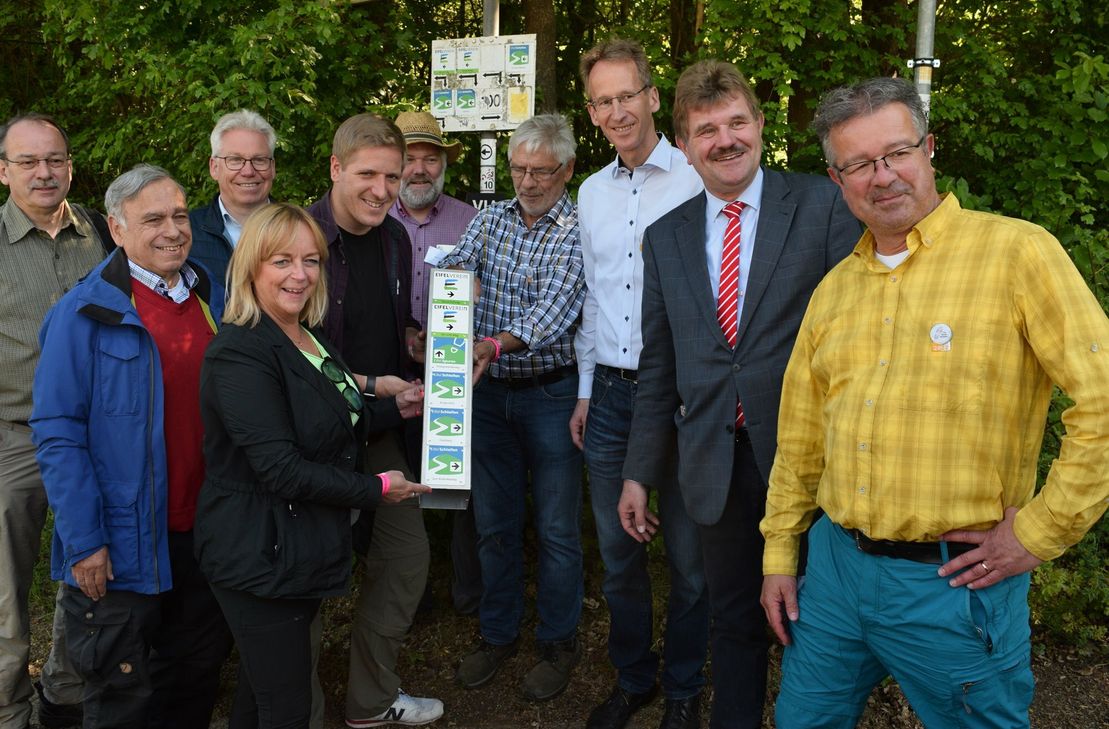 Gemeinsam brachten die Gäste und Ausrichter der Zentralveranstaltung zum Tag des Wanderns, darunter auch Manuel Andrack (re.) eine neue Markierung für mehrere Wanderwege in Bad Münstereifel an. Foto: Scholl