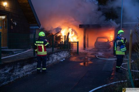 Wehrleute beim Löschen eines Garagenbrandes