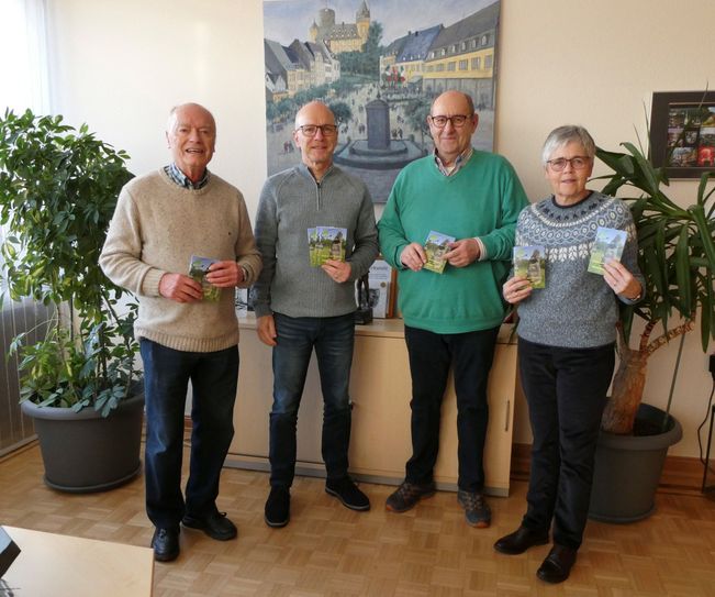 Der Vorsitzende Joachim Rogalski und seine Kollegen überreichten den Wanderplan.