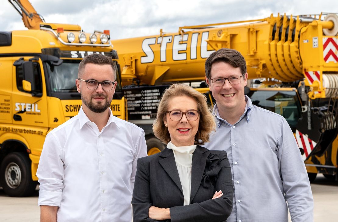 Im Jahr 2024 feiert "Steil Kranarbeiten" 100-Jähriges. Seit 1989 leitet Birgit Steil das Trierer Unternehmen, seit 2022 mit ihren Söhnen Daniel Gödert (rechts) und Christopher Steil (links) in der Geschäftsführung.