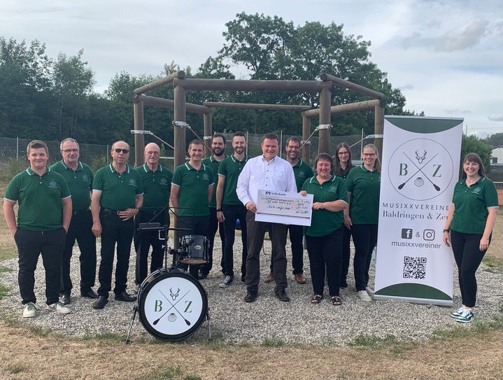 Regionaldirektor Dirk Müller überreicht den Check in Höhe von 4.045 Euro an Vertreter*innen der Musixxvereiner Baldringen & Zerf . Foto: Verein