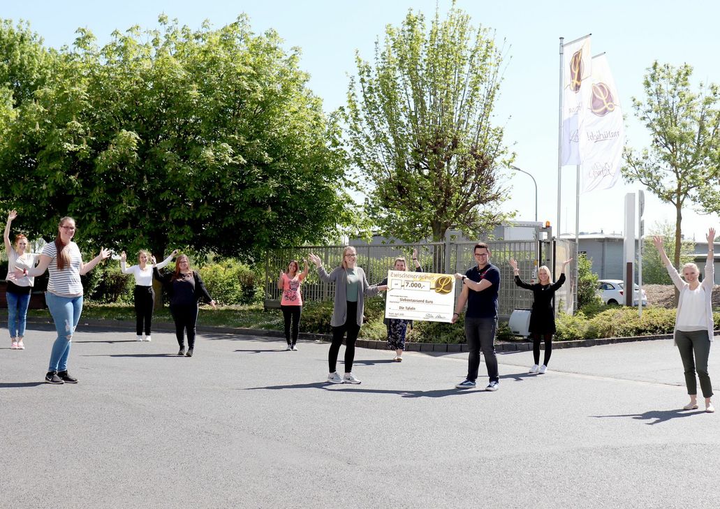 Mitarbeiterinnen und Mitarbeiter der Bäckerei "Die Lohner's" präsentieren symbolisch den Spendenscheck für die Tafeln.