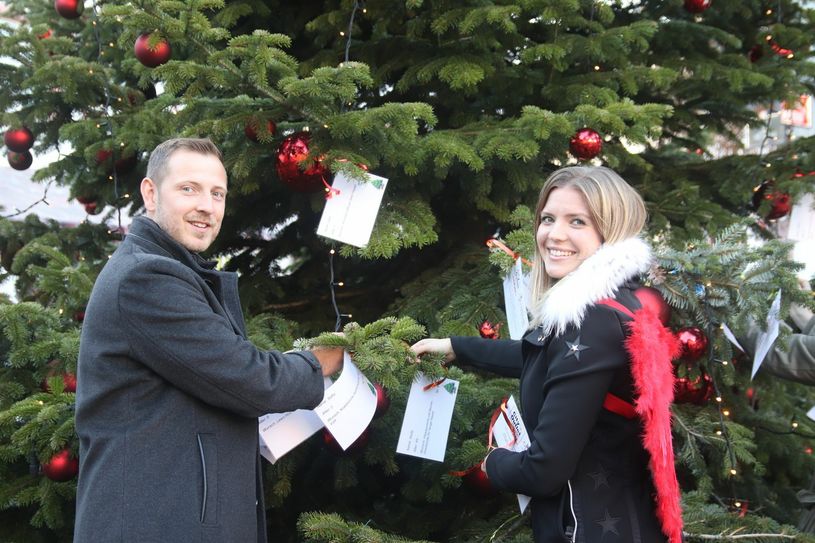 Center-Manager Lars Wenniga (l.) und Caren Brucherseifer, Vorsitzende der Cöllnischen Stiftung, hängen die laminierten Wünsche am Baum auf.Foto: Tim Nolden