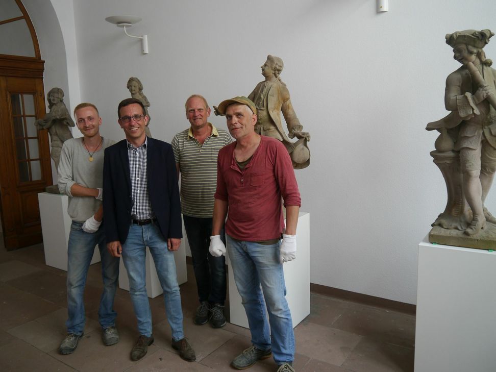Dezernent Thomas Schmitt nimmt die restaurierten Figuren an ihrem neuen Standort in Augenschein. V.l.n.r.: Leo Greif (Mitarbeiter der Werkstatt Henning Wirtz),Thomas Schmitt (Kulturdezernent der Stadt Trier), Thomas Knopp (Werkstattleiter Stadtmuseum Simeonstift) und Henning Wirtz (Steinmetz). Foto: Stadtmuseum Simeonstift Trier