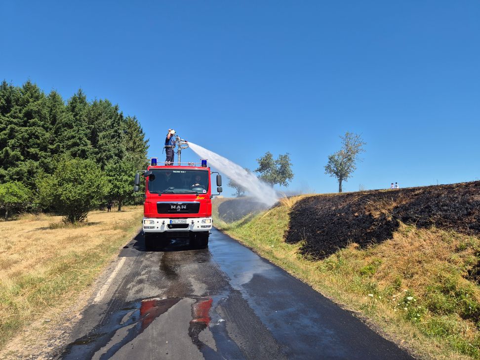 Das Feuer breitete sich rasend schnell aus und erfasste neben der Feldfläche auch bereits gepresste Strohballen sowie mehrere Obstbäume. Eine weithin sichtbare Rauchsäule stand über der Einsatzstelle.