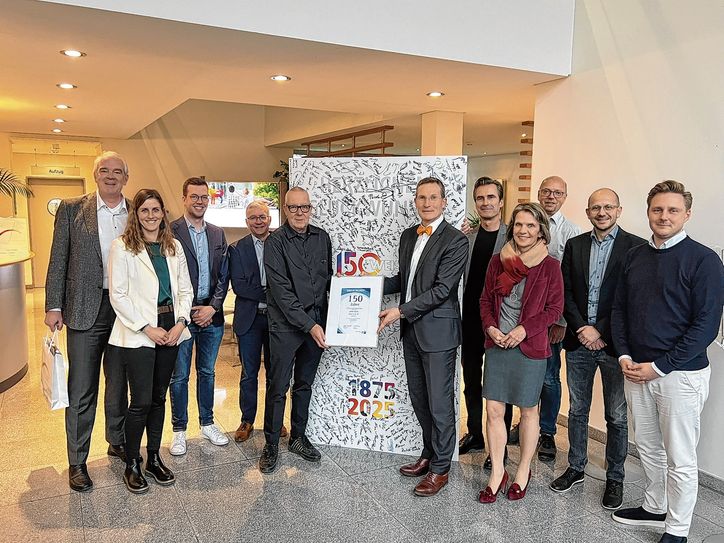 Führende Vertreter der verschiedenen Geschäftsbereiche des Medienhauses Weiss und Monschaus Bürgermeisterin Dr. Carmen Krämer (2.v.l.) wohnten der Übergabe der Urkunde der Industrie- und Handelskammer Aachen bei. IHK-Hauptgeschäftsführer Michael F. Bayer überreichte sie an den Inhaber des Familienunternehmens, Georg Weiss (5.v.l.) und dessen Sohn Leonard (3.v.l.).