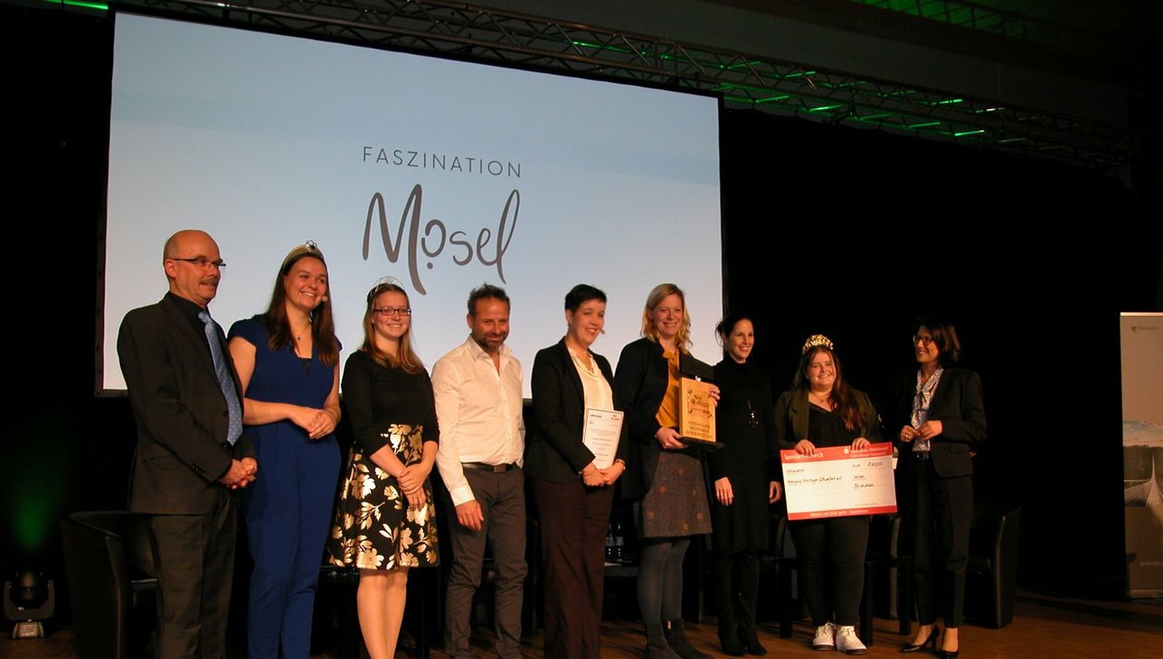 Staatsministerin Daniela Schmitt (re.) freute sich gemeinsam mit den neuen #moselhelden - hier die VertreterInnen der Vereinigung Mehringer Winzerfest e.V., Mehring (Landkreis Trier-Saarburg) - über die Auszeichnung beim 13. Mosel-Kongress.