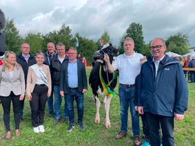 Miss Hochwald im Mittelpunkt: Siegerkuh Moldau vom Eichenhof in Musweiler mit ihrem Besitzer Matthias Zens, umringt von Gratulanten, darunter VG-Bürgermeister Jürgen Dixius und Milchkönigin Anne Schmillen.