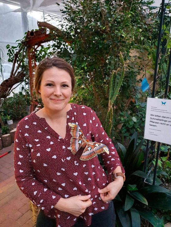 Ulla Große Meininghaus und der große Atlasspinner im Schmetterlingsgarten Eifalia. Fotos: Privat