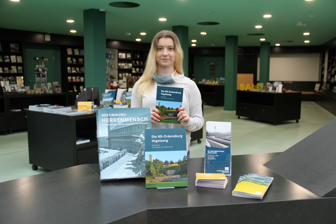 Führungen, Bildung und das Shop-Angebot: Vogelsang-IP-Mitarbeiterin Marie Breuer präsentiert die Vielfalt der Möglichkeiten. Foto: Vogelsang IP