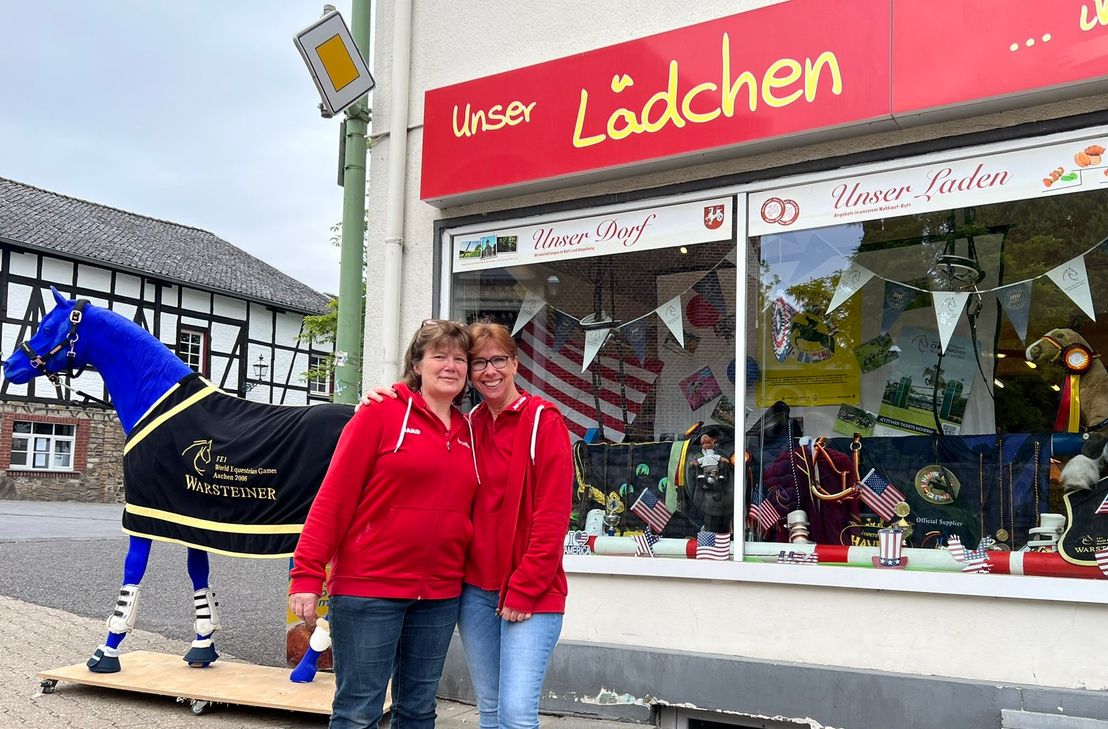 Ein blaues Pferd, das in dieser Farbe einzigartig ist und zur Reit-WM 2006 erstellt wurde, ziert den Ortsmittelpunkt von Rott. Gleichzeitig macht es auf das Schaufenster des »Rotter Lädchen« aufmerksam, das Heike Heinrichs, Uschi Furch und ihre Kolleginnen zur Aktin »Tschio chic« dekoriert haben. »Einkaufen und abstimmen«, wirbt Filialleiterin Heinrichs - dem Lädchen winkt ein Geldpreis, den Kunden eine Reise.