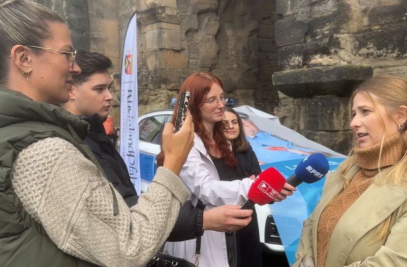 Auch Influencerin Liesa Maier (vorne) unterstützt die Kampagne gegen Callcenter-Betrug und interessiert sich für die Arbeit der Polizei Rheinland-Pfalz.