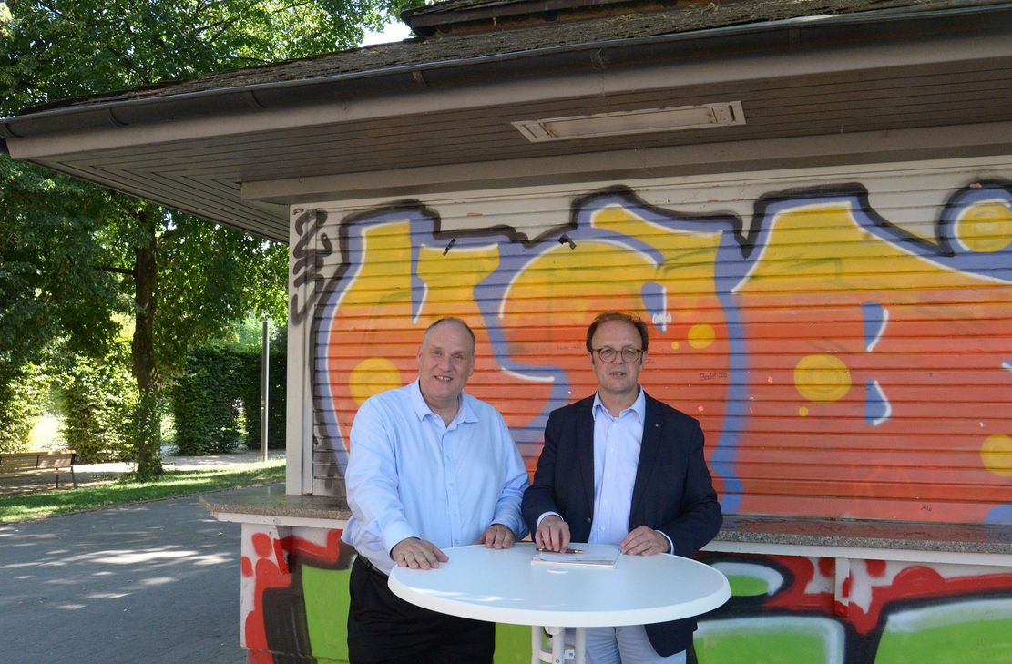 Nach der Vertragsunterzeichnung vor dem Kiosk im Palastgarten freuen sich Innenstadtdezernent Ralf Britten (r.) und Pächter Niels Becker auf die Zusammenarbeit.