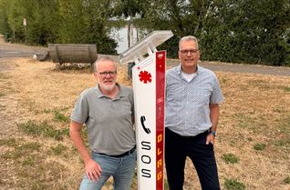 Bürgermeister Ulf Hürtgen (r.) und Ordnungsamtsleiter Werner Lorse machten sich jetzt vor Ort ein Bild von der neuen Notrufsäule am östlichen Ufer des Wassersportsees.