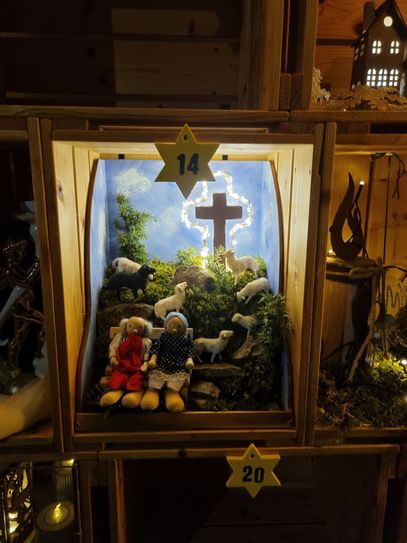 Auch Kiste 14 hat wieder einen lokalen Bezug: Es wurde der Gipfel des Alendorfer Kalvarienberges nachgebaut, inklusive Wacholderbüsche, Schafherde und dem markanten Kreuz mit seiner Weihnachtsbeleuchtung, die momentan tatsächlich installiert ist.
