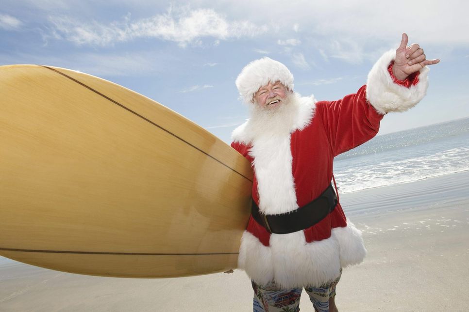 Der Weihnachtsmann mit Surfboard am Strand: In Australien ein kein ungewöhnlicher Anblick, denn hier liegt Weihnachten mitten im Sommer Foto: imago images / Panthermedia