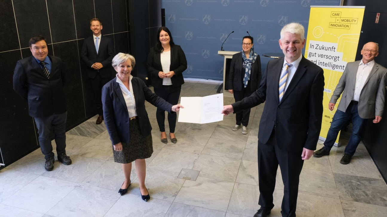 Staatssekretär Christoph Dammermann übergibt den Zuwendungsbescheid für »Care and Mobility Innovation« an Prof. Dr. Christiane Vaeßen, Geschäftsführerin Region Aachen Zweckverband. Foto: MWIDE NRW