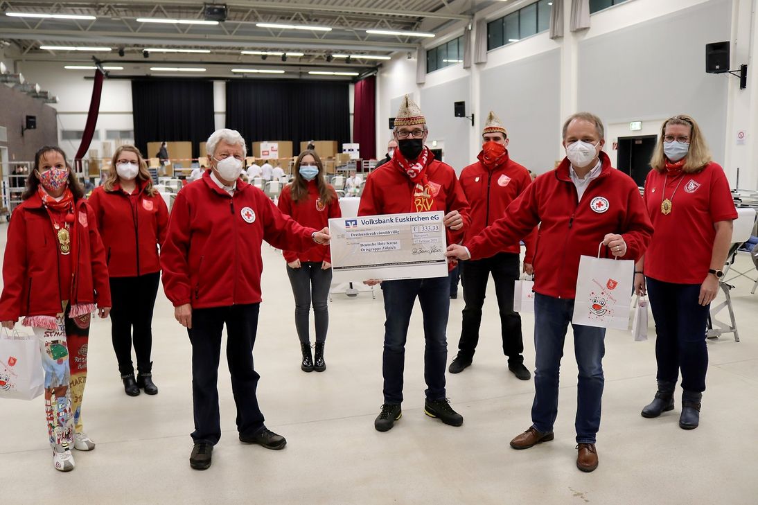 Alles auf Rot: Präsident Jürgen Hoscheid (4.v.r.) und weitere Mitglieder des Bürvernicher Karnevalsvereins überreichten dem DRK-Ortsverein, vertreten durch dessen Vorsitzenden Lothar Henrich (3.v.l.) und Gemeinschaftsleiter Thomas Heinen (2.v.r.), einen Scheck über 333,33 Euro. Foto: Thomas Schmitz/pp/Agentur ProfiPress#
