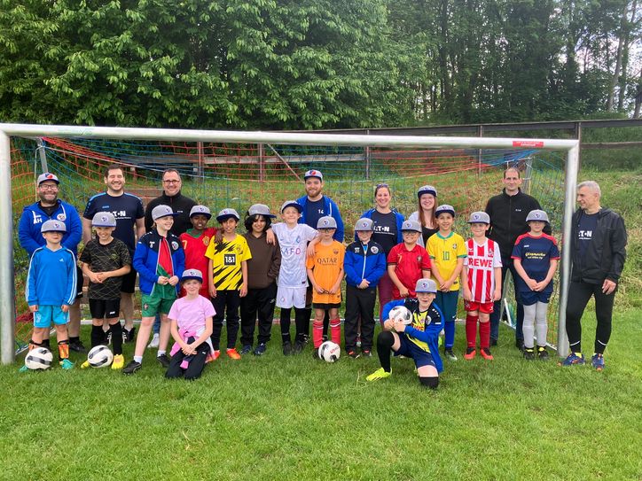 Die Kids der Jugendspielgemeinschaft Mechernich-Feytal-Weyer und Mitarbeiter von Eaton bei der Übergabe der neuen Baseballcaps.