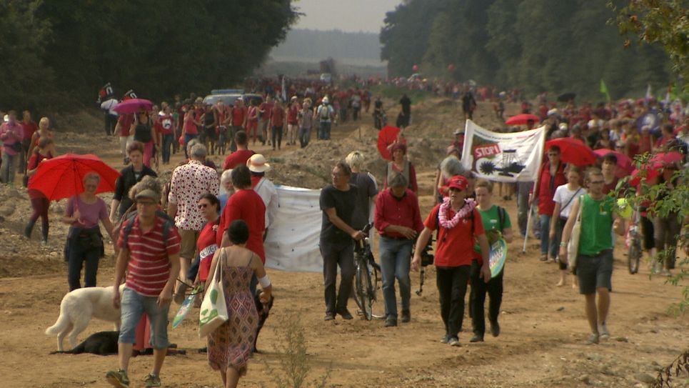 Tausende demonstrieren gegen Braunkohle.Im August 2017 bildeten 3.000 Menschen eine rote Linie entlang der alten A4 und stellten sich damit schützend vor dem Hambacher Forst.