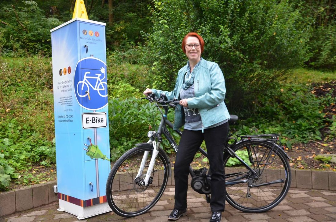 Nicht nur dem eigenen E-Bike kann Ruth Breuer an der neuen Ladestation für Elektrofahrräder an der Monschauer Senfmühle auftanken.Foto: T. Förster