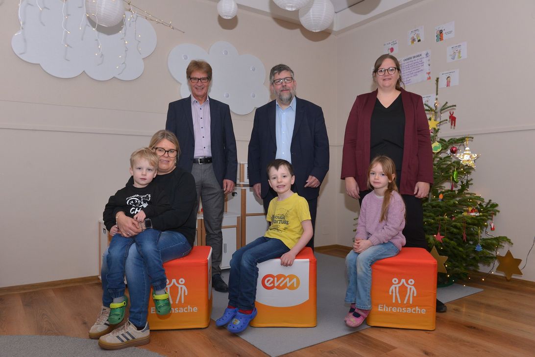 Berthold Nick von der evm übergibt den Spendenbetrag gemeinsam mit Bürgermeister Wolfgang Lambertz an die Vertreter und Vertreterinnen des Kindergartens.
