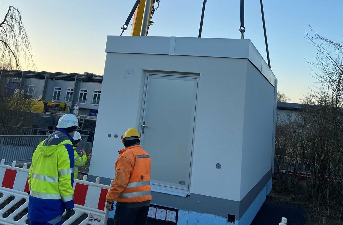 Auf den Millimeter genau wird der Point of Presence (PoP) mit dem Kran auf den bereits vorbereiteten Platz transportiert.