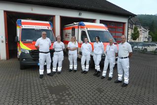 Foto 1: Beatrix Herrmann (2.v.re.) und Jörg Fröhlich (re.) vom DRK-Kreisverband Rhein-Hunsrück mit ihren Kollegen Ralf Vianden, Anna Rosenbaum, Lucie Männicke, Michelle Klapperich und Lena Stenger (v.li.) vom DRK Ahrweiler vor der Rettungswache in Adenau.