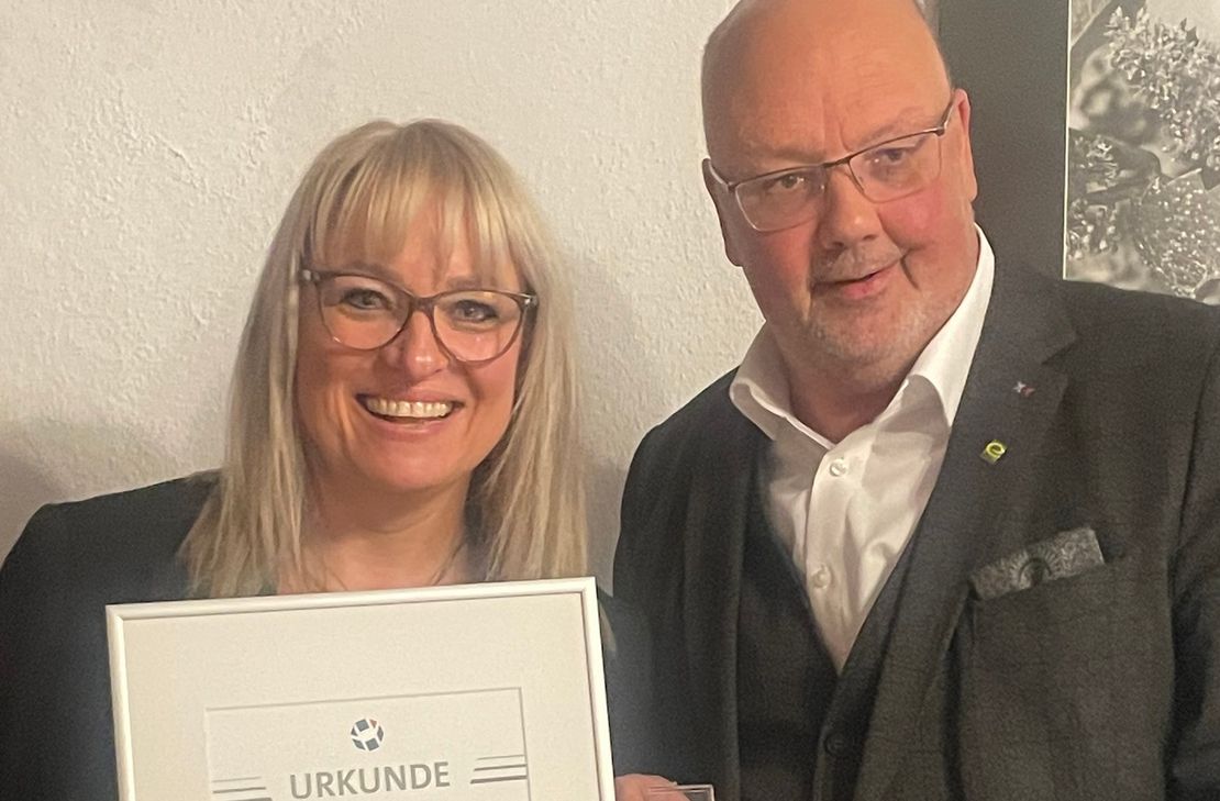 Sabine Schömann-Kuhnen freut sich über die Auszeichnung mit der Goldenen Ehrennadel der Kreishandwerkerschaft MEHR, die ihr von Geschäftsführer Dirk Kleis überreicht wurde.