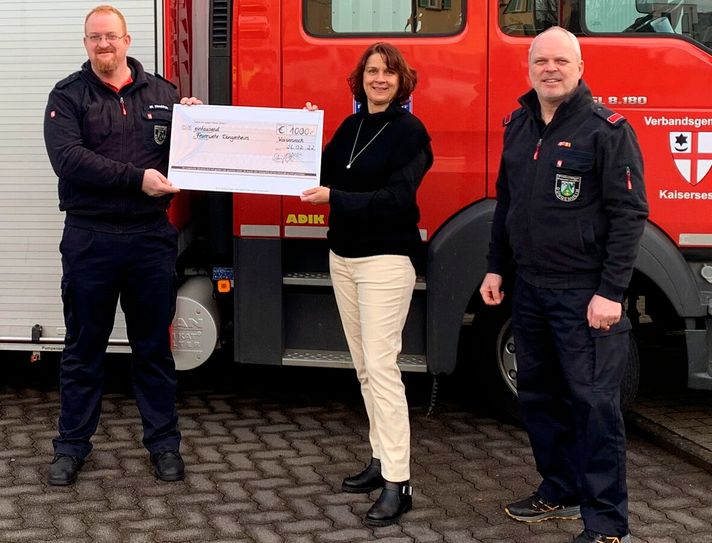 Anja Schäfges vom Pannen- und Abschlepp-Service Schäfges hat Oliver Neukirch (links) und Gerhard Knauf  von der Freiwilligen Feuerwehr Düngenheim einen Spendenscheck in Höhe von 1.000 Euro überreicht.