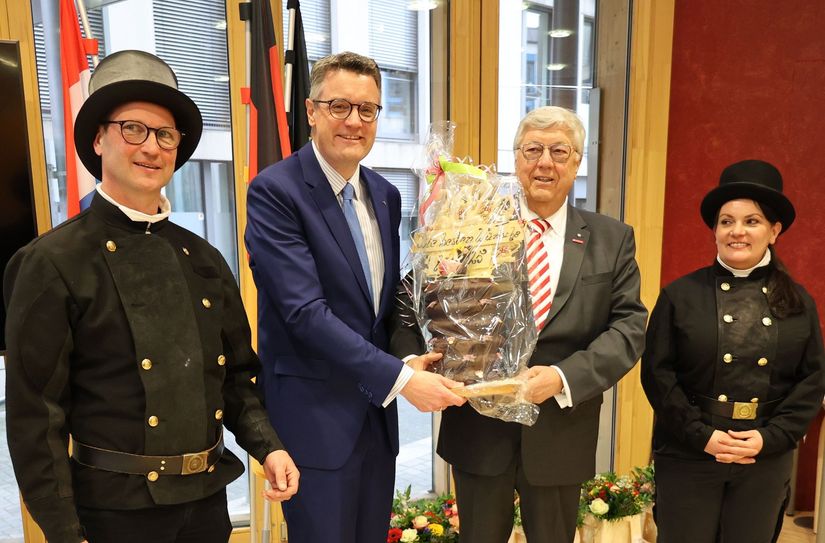 Kreishandwerksmeister Herbert May (2.v.r.) überreicht den traditionellen Baumkuchen an Städteregionsrat Dr. Tim Grüttemeier (3.v.r.).