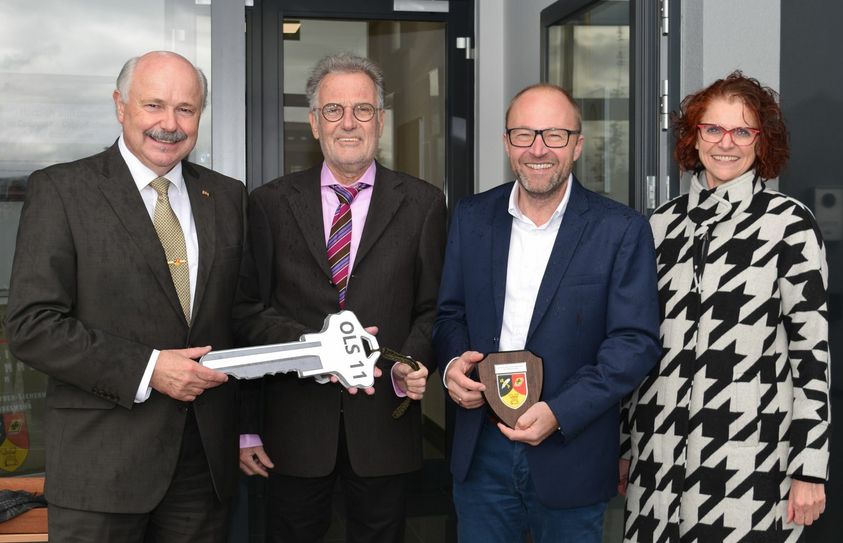 Im Beisein von Euskirchens Bürgermeister Dr. Uwe Friedl (2.v.li.) und Architektin Monika Brölingen (re.) überreichte Bauherr Jörg Wiskirchen (2.v.re.) den symbolischen Schlüssel für das neue Gebäude des Zentrums für Cyber-Sicherheit der Bundeswehr in Euskirchen an dessen Direktor Hans-Ulrich Schade (li.). Foto: Scholl