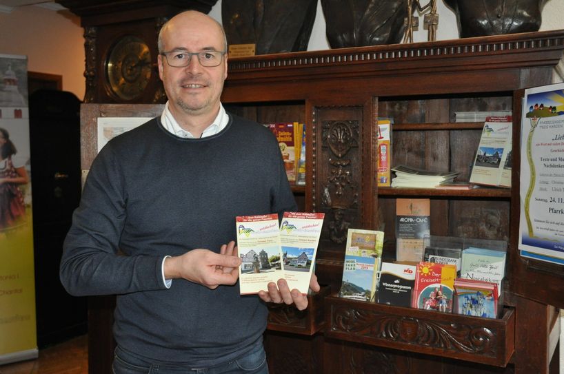 Oliver Bell präsentiert die Flyer des neuen Ratespiels "Treis-Karden entdecken".