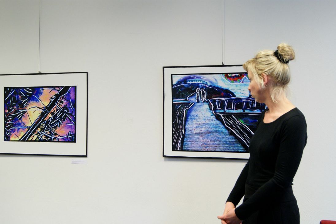 Am Anfang der Vernissage erklärte Stefanie Manhillen die Machart ihrer Bilder und die Motivation die dahintersteckt. Foto: Woltmann