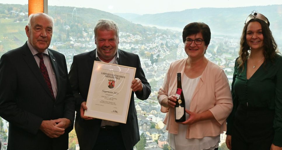 Der Kammerpräsident, Ökonomierat Norbert Schindler (links), und die Moselweinkönigin, Sarah Röhl, überreichen die Siegerweinurkunde für das Weingut Lönartz-Thielemann an Hans-Georg und Beate Lönartz.