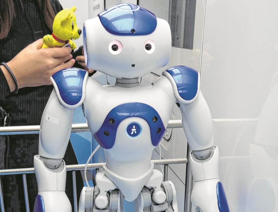 Eine Schülerin experimentiert mit Roboter NAO.