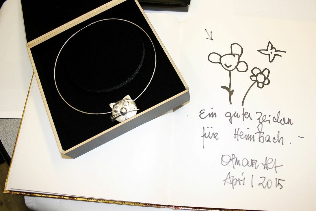 Otmar Alts Eintrag in Goldene Buch der Stadt und das von der Goldschmiedin Anja Schlader nach seinen Entwürfen gefertigte Katzen-Collier "Kosma". Fotos: Beate Weiler-Pranter/pp/Agentur ProfiPress