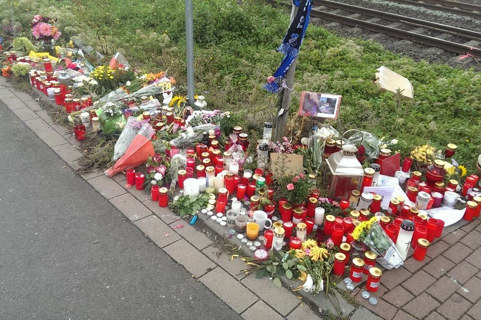 Auf dem Grünstreifen am Bahnübergang werden Kerzen angezündet und Blumen niedergelegt.  Foto: Schmitt