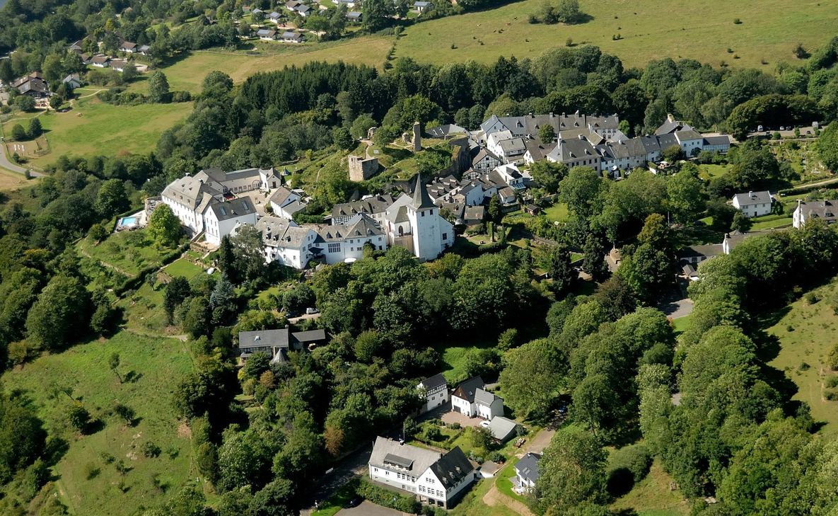 Die ehemalige Schule in Kronenburg, die  im Vordergrund zu sehen ist, kann in Zukunft mit Fördermitteln des Landes saniert werden.  Foto: Gemeinde Dahlem