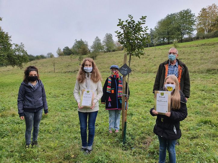 Valerie Schneider (l.), Thea Merkelbach (M.) und Leo Lenerz (2.v.r.) freuen sich, mit Maya (2.v.l.) und Sara Merkelbach (r.) drei ganz junge Baumpatinnen dabei zu haben. Foto: GesundLand Vulkaneifel